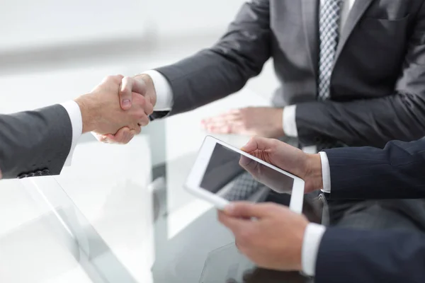 Dos hombres de negocios seguros estrechando la mano durante una reunión en el — Foto de Stock