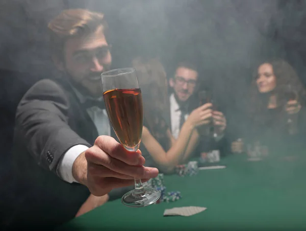 Pokerspeler heft een glas wijn — Stockfoto