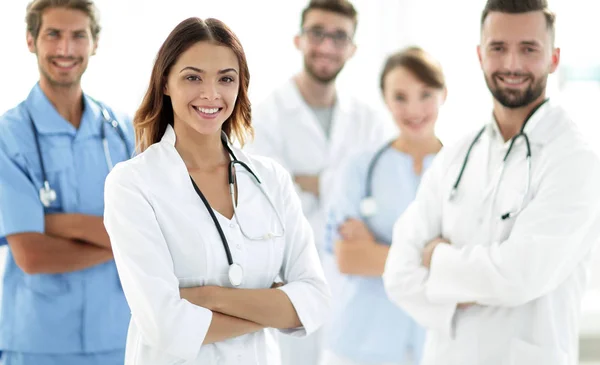 Attraente medico femminile con stetoscopio medico di fronte al gruppo medico — Foto Stock