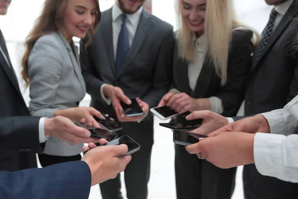 Detailní záběr chytrých telefonů v rukou podnikatelské mládeže — Stock fotografie