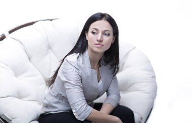 Genç kadın bir yuvarlak rahat yumuşak büyük sandalyede oturuyor.