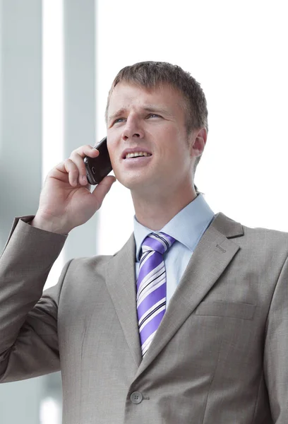 Empresario en la ventana hablando por teléfono — Foto de Stock