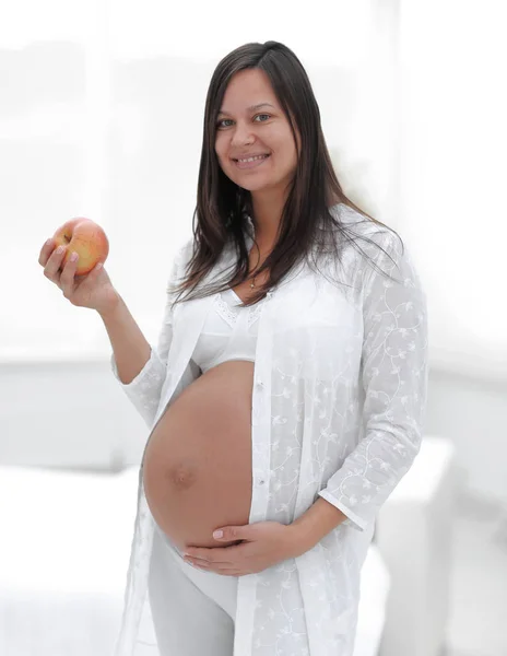 Leende gravid kvinna med ett äpple — Stockfoto