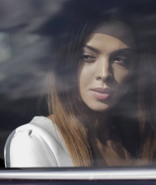 Hermosa morena de negocios mira por la ventana en el coche . — Foto de Stock