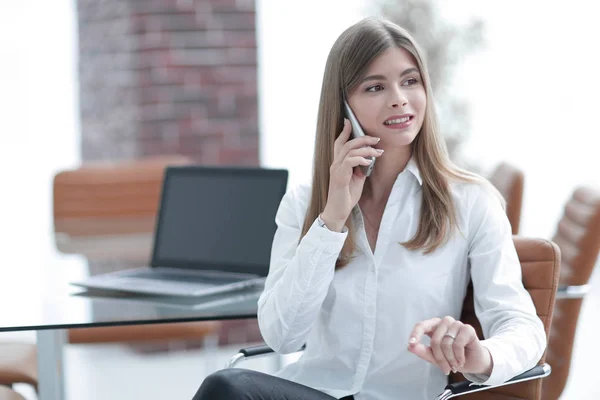 Donna d'affari che parla al cellulare seduta in ufficio — Foto Stock