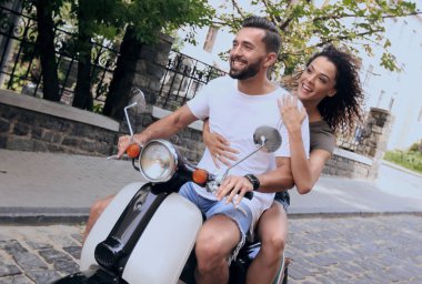 Şık genç çift bir scooter sokakta oturuyor..