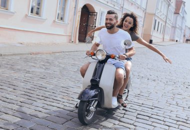 mutlu genç bir çift bir scooter üzerinde eğleniyor
