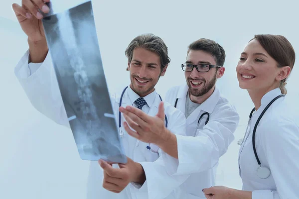 Tre medici fiduciosi esaminano una radiografia — Foto Stock