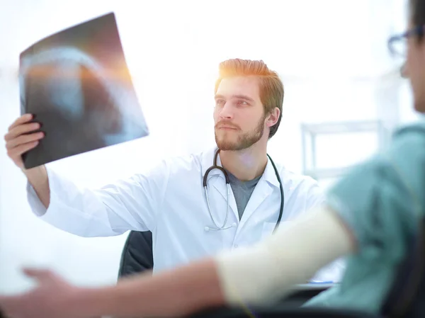 Ortopedista examinando uma radiografia de um paciente — Fotografia de Stock