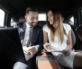 Mann und Frau diskutieren im Taxi über Arbeitspapiere