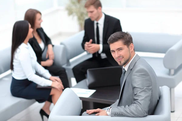 Hombre de negocios sentado en una oficina en el fondo del equipo de negocios . — Foto de Stock