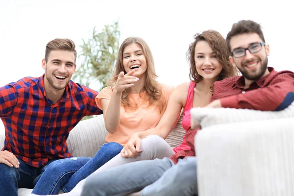 Skupina happy mladých lidí sedí na gauči — Stock fotografie