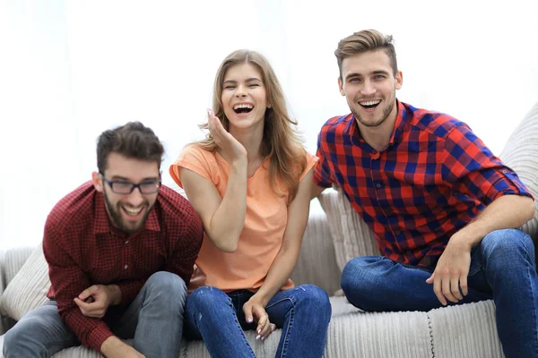 Group of young people laughing and sitting on the couch — Stock Photo, Image