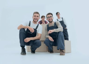 Kutuları yığını tutan genç teslim erkekler gülümseyen. W izole