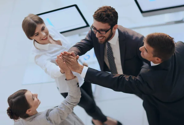 Odnoszący sukcesy zespół biznesowy przybija sobie piątkę, stojąc w biurze — Zdjęcie stockowe