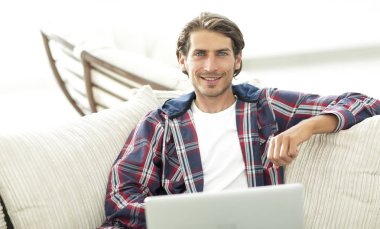 dizüstü bilgisayarda çalışan ve kameraya bakarak başarılı adam. Yukarıdan görüntülemek