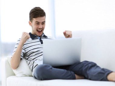 mutlu adam kanepede oturan dizüstü bilgisayar ile