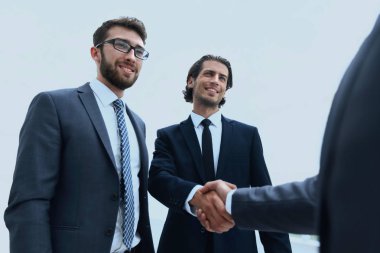 İş ortakları el sıkışarak ortağa hoş geldin diyor