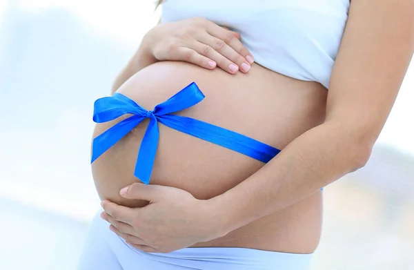 Szczęśliwa kobieta w ciąży mierzy brzuch i talię. — Zdjęcie stockowe