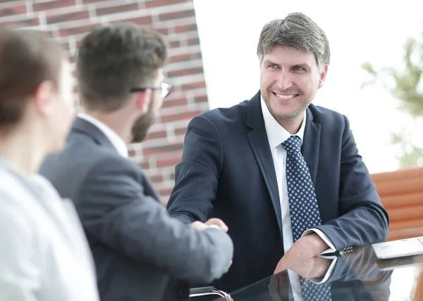 Apretón de manos de la gente de negocios en el escritorio — Foto de Stock