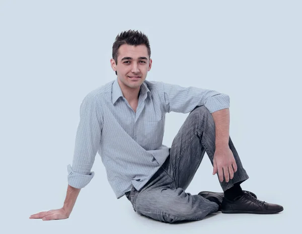 Современный молодой человек, сидящий на полу — стоковое фото