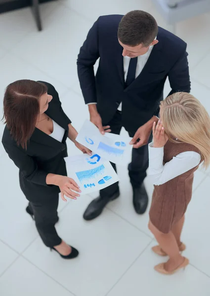 Vista de cima. equipe de negócios discutindo gráficos financeiros em pé no escritório — Fotografia de Stock