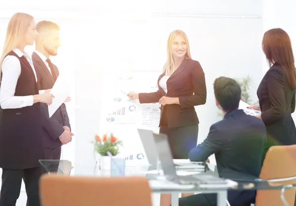 Mujer de negocios señalando un puntero en un rotafolio — Foto de Stock