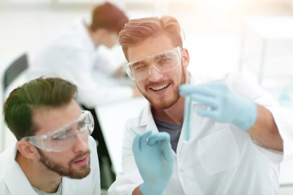 Two biologist examining liquid in a test tube — Stock Photo, Image