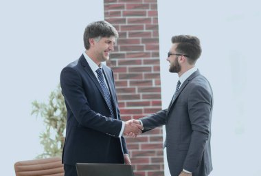 ofis koridorunda duran el sıkışan işadamları