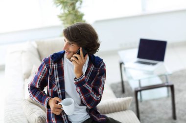 güzel bir fincan adamla bir dizüstü bilgisayar önünde oturur.