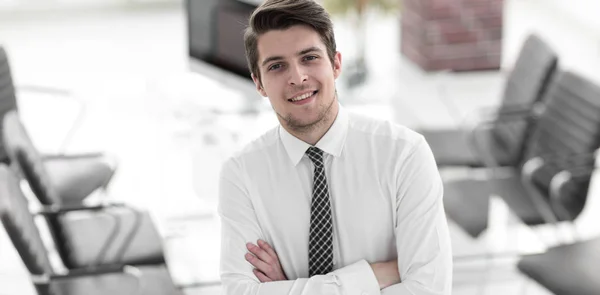 Självsäker ung affärsman på bakgrund av office — Stockfoto