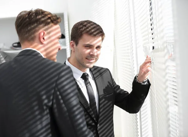 Üzletemberek néz ki az ablak irodában — Stock Fotó