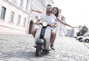 mutlu genç bir çift bir scooter üzerinde eğleniyor