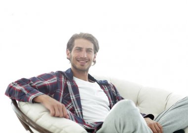 gülümseyen bir adam büyük bir koltukta otururken köpeğini okşayarak Close-Up.