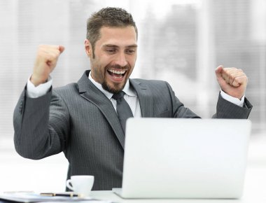 açık bir dizüstü bilgisayar önünde oturup closeup.happy iş adamı.