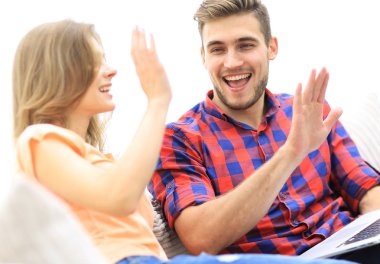 dizüstü bilgisayar ile gülümseyen genç bir çift closeup