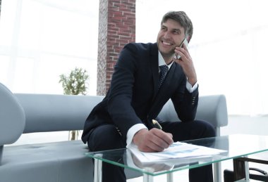 İş yerinde akıllı telefonu olan bir iş adamı.