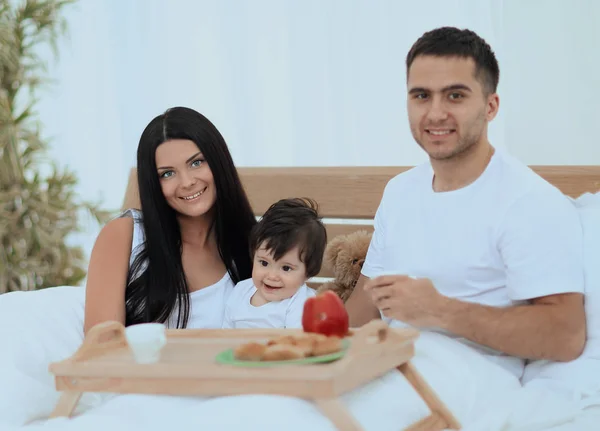 Famille prenant le petit déjeuner au lit à la maison — Photo