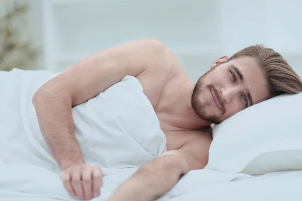 Lycklig man, somna i en skön säng — Stockfoto