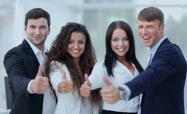 Equipe de negócios triunfante segurando polegares para cima — Fotografia de Stock