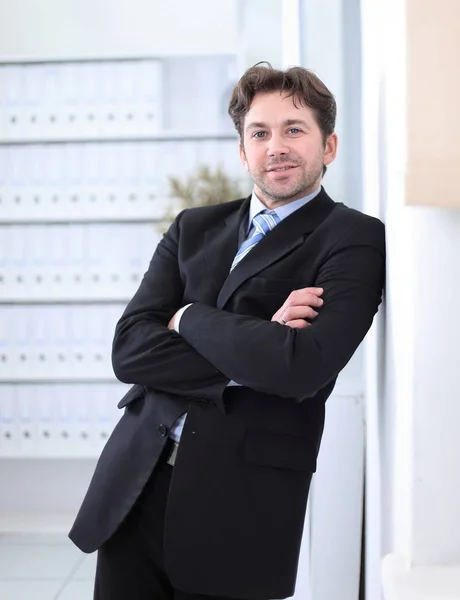 Closeup.Handsome επιχειρηματίας στέκεται στο παρασκήνιο του γραφείου — Φωτογραφία Αρχείου