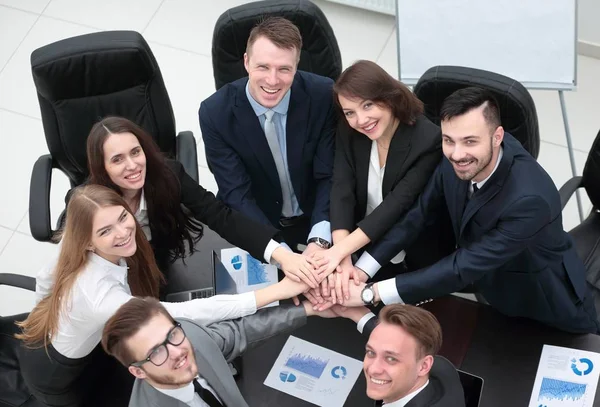 Equipo de negocios con las manos juntas en el escritorio —  Fotos de Stock