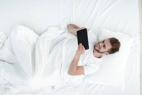 Homem bonito digitando em um tablet digital — Fotografia de Stock