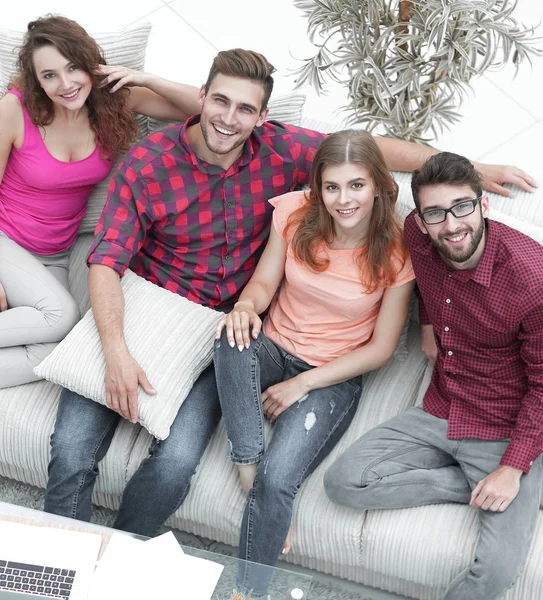 Blick von oben. Die vier Freunde lachen, sitzen auf dem Sofa — Stockfoto