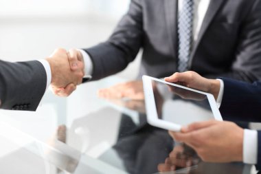 Bir toplantı sırasında el sıkışan iki emin iş adamları