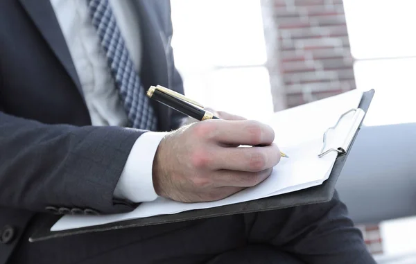 Επιχειρηματίας που γράφει σε ένα σημειωματάριο σε ένα γραφείο — Φωτογραφία Αρχείου