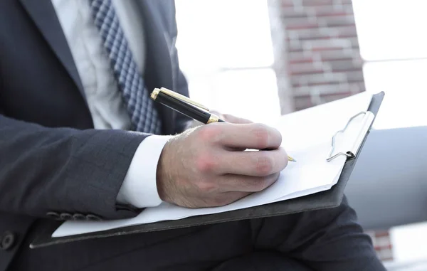 Zakenman schrijven in een notitieblok in een kantoor — Stockfoto