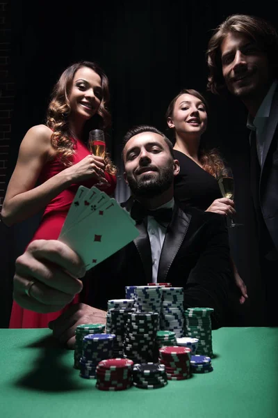 Concentrated men and women playing poker in casino — Stock Photo, Image