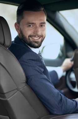 Kameraya bakarak bir arabanın ön koltuğunda otururken yakışıklı genç