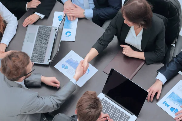 De financiële partners handdruk op uw bureau — Stockfoto